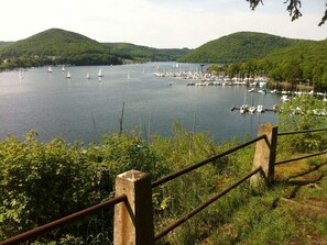 Una vista panorámica de un lago con numerosos veleros y un puerto deportivo.