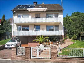 A two-story residential building with a balcony, solar panels on the roof, and a car parked in the driveway. - Ferienwohnungen Haus Herdlitschke by Interhome (Polle)