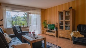 Ein Wohnzimmer mit einer Couch, einem Couchtisch, einer TV-Konsole und einem Schrank.