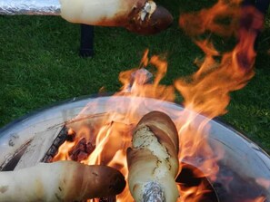Ein Grill mit Bratwürsten, die über offenem Feuer zubereitet werden.
