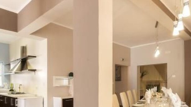 Una cocina moderna con armarios blancos y una campana extractora de acero inoxidable.