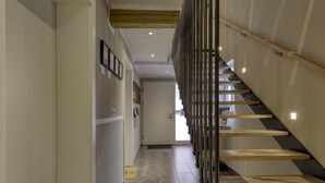 Een modern interieur met een trap, een gang en een deur naar een andere kamer.