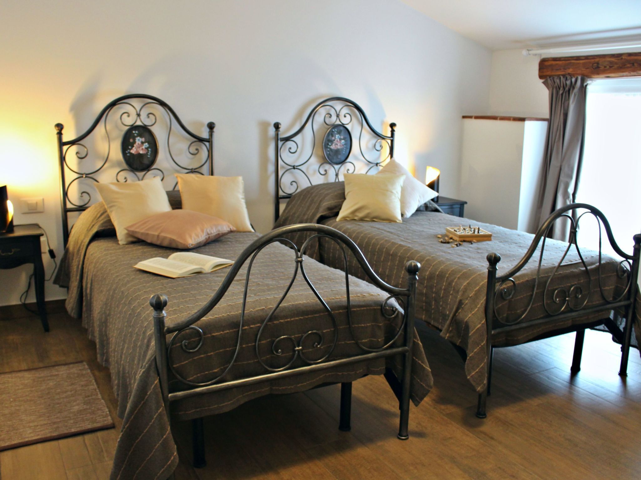 A bedroom with two beds, each with a headboard and a bedside table.