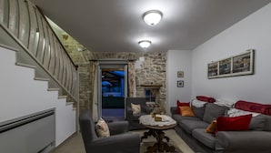 A living room with a stone wall, a staircase, and a sofa set. - VILLA CON WELLNESS A 1 KM DAL MARE by Interhome (Umag/Juricani)