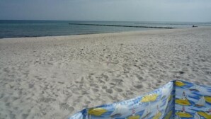 Ein Strand mit sandigem Ufer und blauem Himmel.