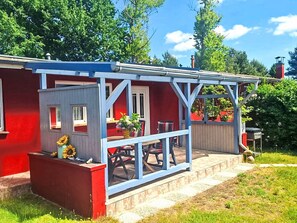 A red building with a blue porch and a small garden area. - Antonia by Interhome (Bodstedt)