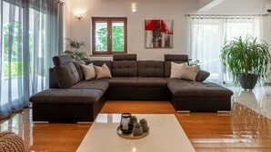 Una sala de estar moderna con un sofá modular, una mesa de centro y una planta en maceta.