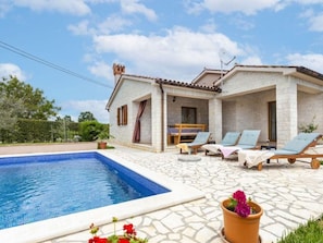 A house with a swimming pool, lounge chairs, and a patio area. - "Villa Mirela" mit Terrasse by Interhome (Barban)