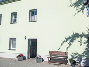Un edificio con varias ventanas, una puerta y un banco.