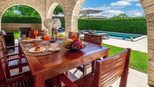 An outdoor dining area with stone arches, a pool, and a view of the landscape. - Casa Mia mit privatem Pool by Interhome (Barban)