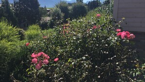 A garden with pink flowers and a mountain backdrop. - Fewo Bergblick lodge by Interhome (Ofterschwang)