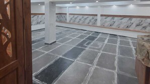 A spacious room with a tiled floor, a marble wall, and recessed ceiling lights. - Celestial Heights (Kanayannur)