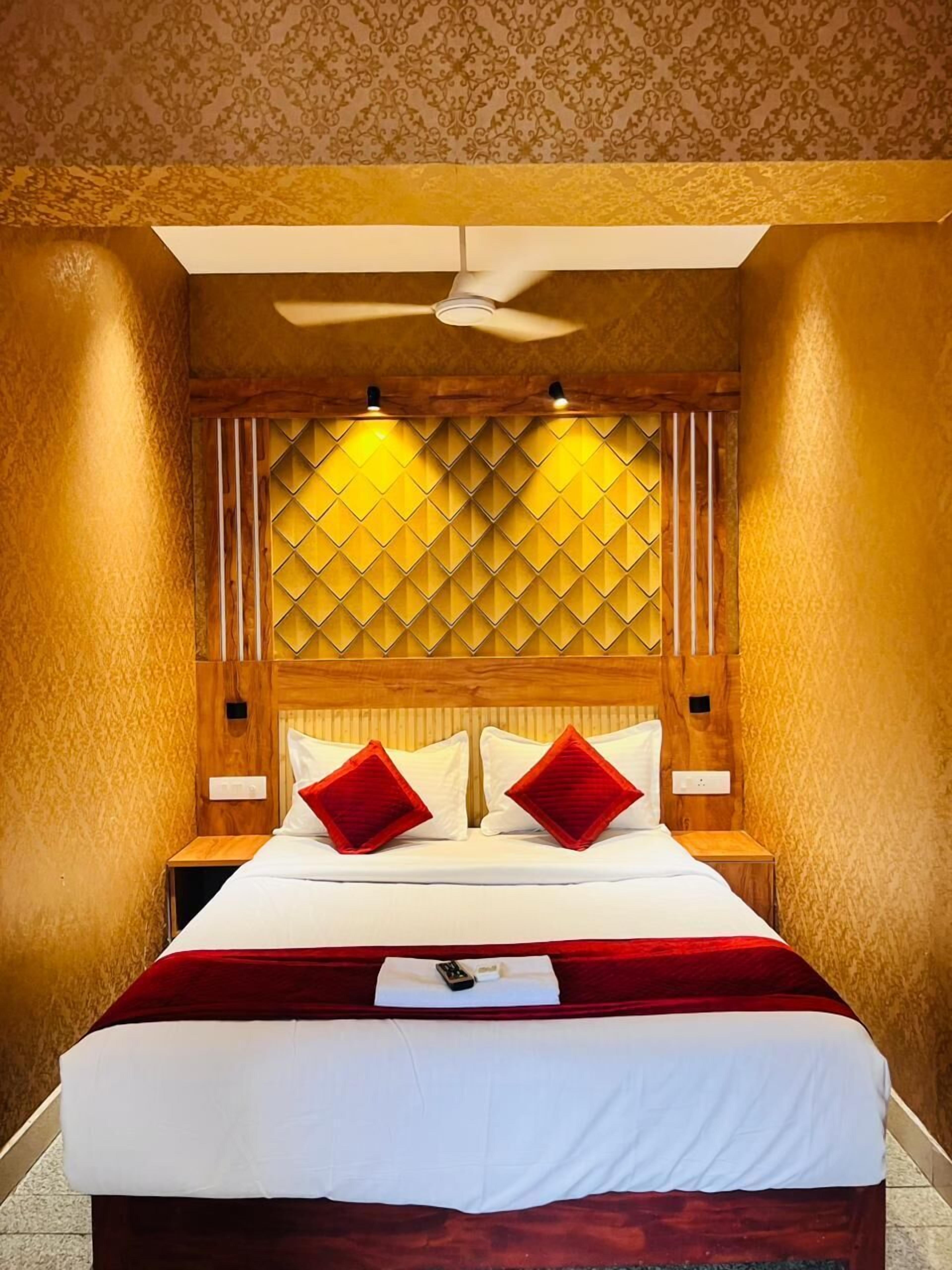 A hotel room with a large bed, wooden headboard, and a ceiling fan.