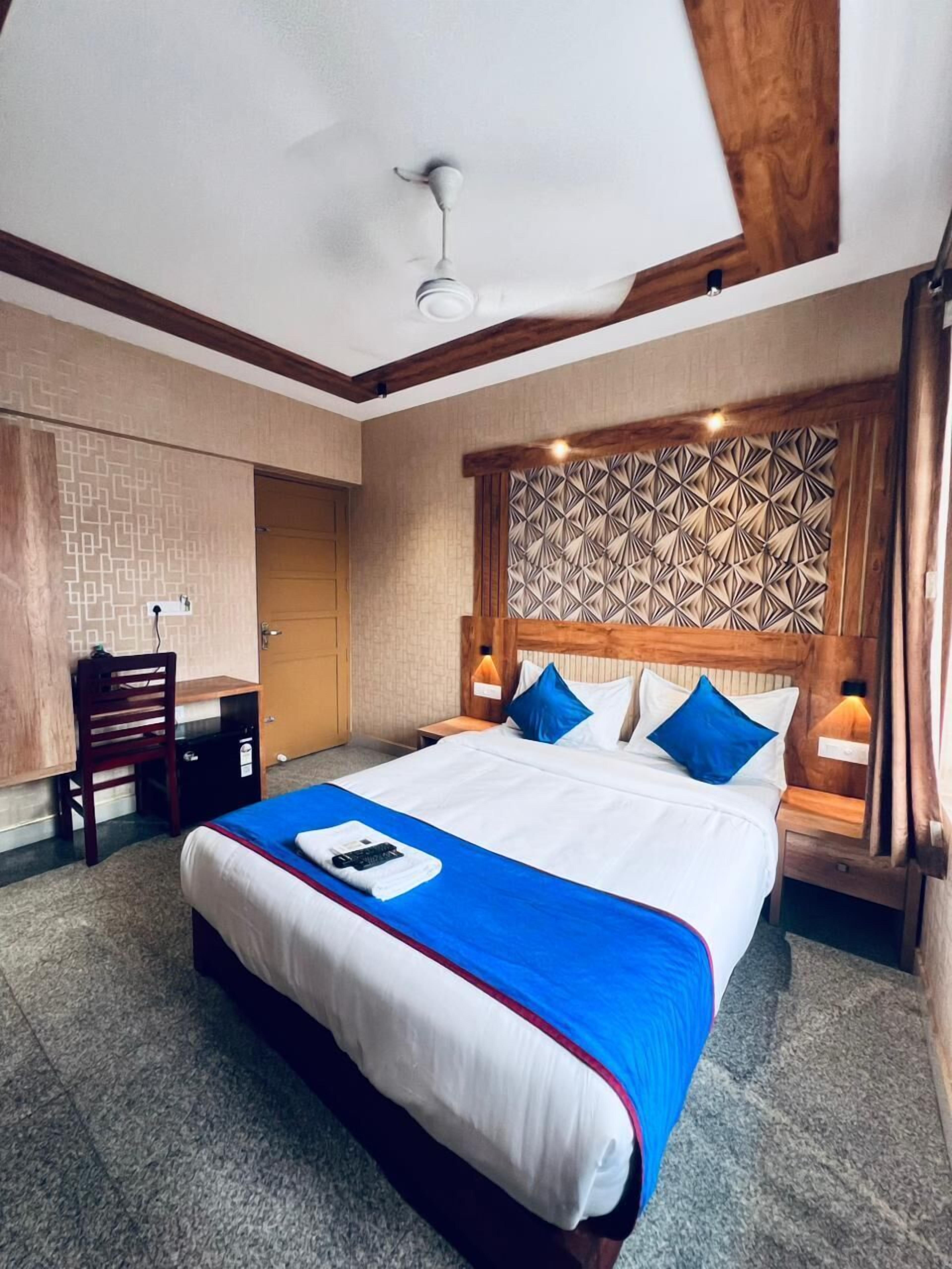 Ein Hotelzimmer mit einem großen Bett, einem Schreibtisch und einem Sessel.
