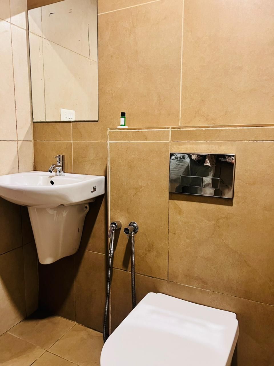 Un baño con lavamanos, espejo, ducha e inodoro.