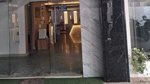 A modern reception area with a marble wall and a reception desk. - Celestial Heights (Kanayannur)