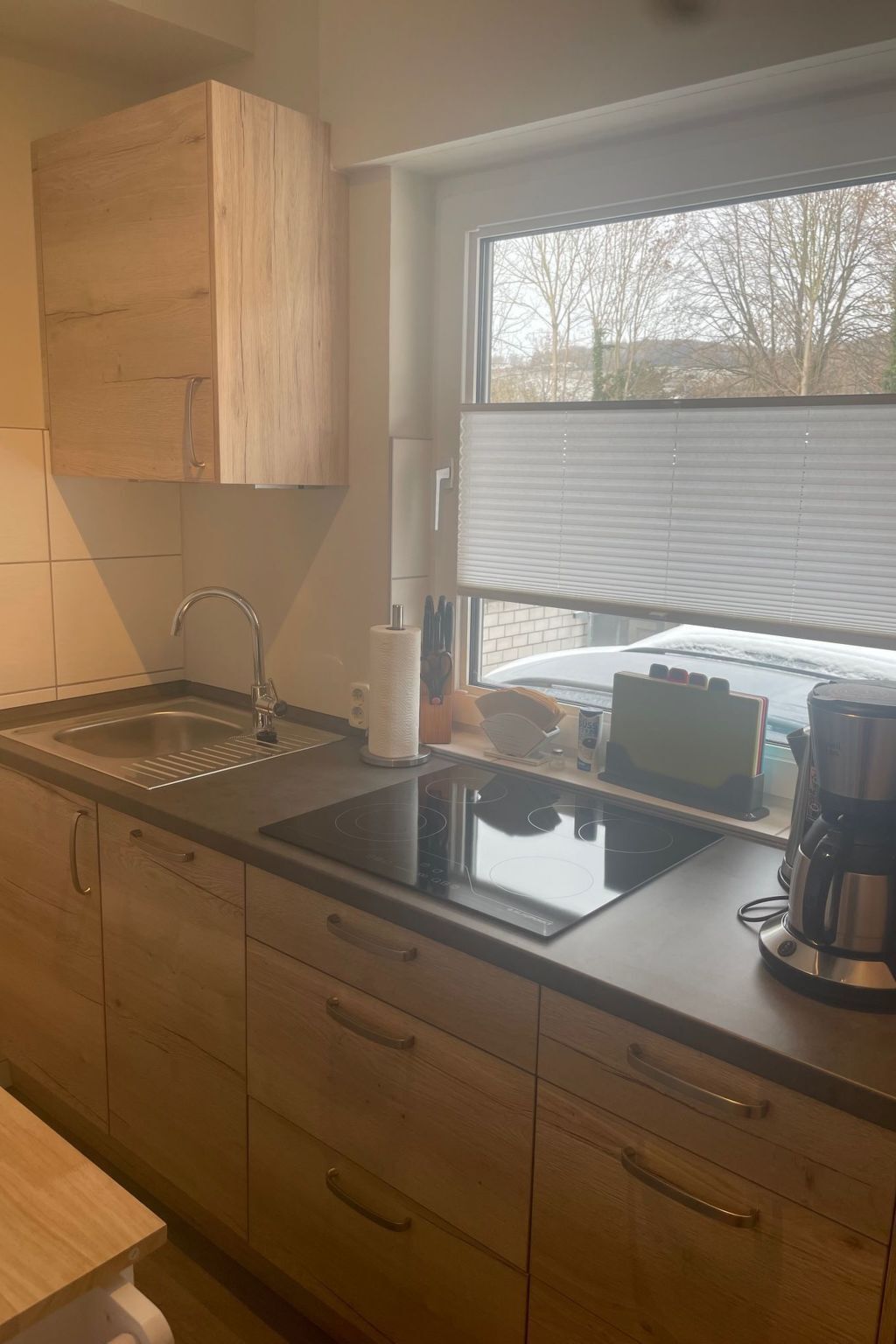 Una cocina con un lavamanos, estufa y ventana.