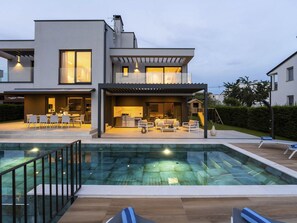 A modern two-story house with a swimming pool, outdoor seating area, and a play structure for children. - Villa Sunset view by Interhome (Poreč)