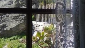 Una ventana con vista a una montaña y una valla de madera.