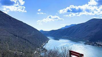 Eine Bank mit Blick auf einen Fluss, im Hintergrund Berge.