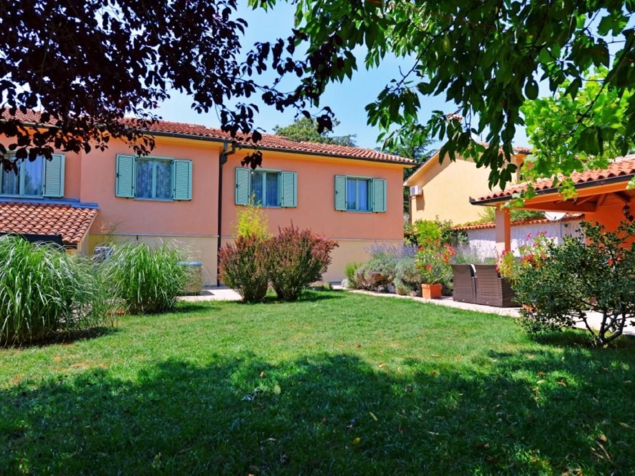 A two-story house with a well-maintained garden and a tiled roof.