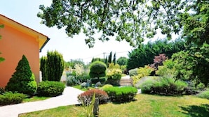 Ein gepflegter Garten mit verschiedenen Sträuchern und einem Weg zu einem Gebäude.