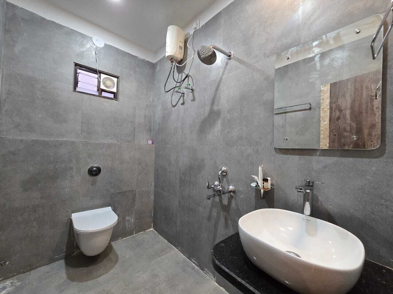 A modern bathroom with a toilet, sink, and shower.