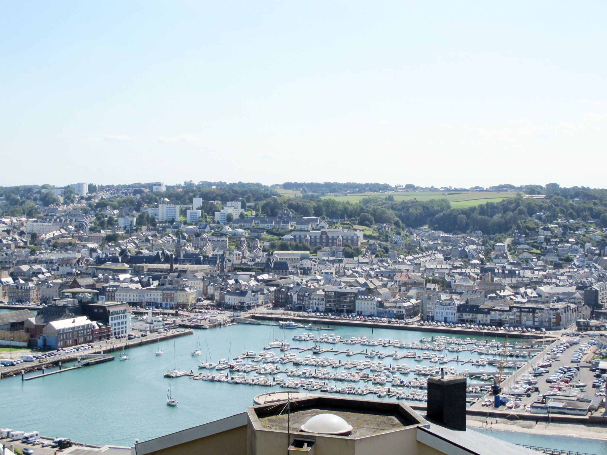 A marina filled with boats, surrounded by a densely packed urban area with various buildings.