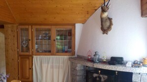 A cozy room with a stone fireplace, wooden cabinets, and a mounted animal head. - Schönes Rustico by Interhome (Dangio – Torre)