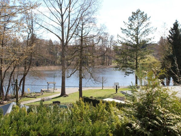 Un parc au bord du lac, doté de bancs, d’un sentier pédestre et d’un panneau indiquant qu’il s’agit d’une zone protégée.