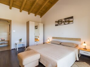 A bedroom with a large bed, a nightstand, a bedside table, a wardrobe, and a mirror. - in Juršići mit Privatem Pool by Interhome (Bokordici)