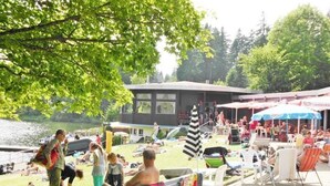 An outdoor seating area with tables and chairs, a dock, and a building in the background. - Premium-Ferienwohnung mit Bergblick im Haus Hopfe by Interhome (Goslar)