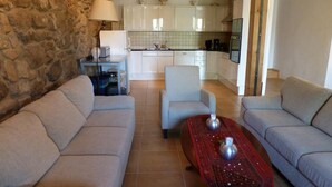 Ein Wohnzimmer mit zwei Sofas, einem Couchtisch und einer Küche im Hintergrund.