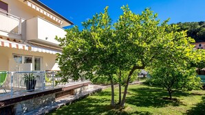 Un edificio con un camino de piedra que conduce a una zona verde con árboles.