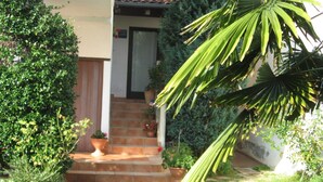 A house with a front porch, steps leading to a door, and potted plants. - Apartment Katja by Interhome (Pula/Banjole)