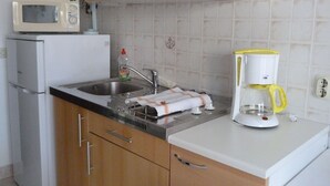 A kitchen with a microwave, refrigerator, sink, and coffee maker. - Apartment Katja by Interhome (Pula/Banjole)