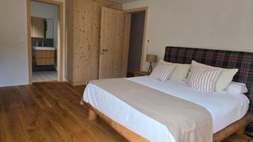 Une chambre à coucher avec un lit en bois, une tête de lit à carreaux et une armoire en bois.