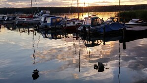 A marina with several boats docked at calm water reflecting the sunset. - Appartement am See by Interhome (Bad Saarow)