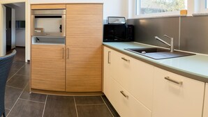 Una cocina moderna con microondas integrado, un fregadero y un ventanal que proporciona luz natural.