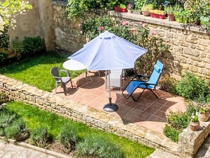 A patio with a table and chairs, a blue umbrella, and potted plants. - Historisches Gourdon by Interhome (Gourdon)