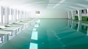 Un área de piscina moderna y espaciosa, con múltiples carriles, agua cristalina y un diseño minimalista.