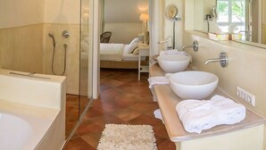 A modern bathroom with a walk-in shower, a bathtub, and a vanity with two sinks. - La Bella by Interhome (Kressbronn)