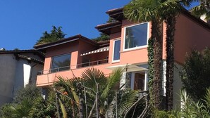 Ein modernes, zweistöckiges Gebäude mit großen Fenstern und einem Balkon.
