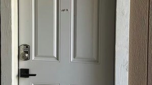 Una puerta blanca con un teclado electrónico y un letrero que indica 'UNIT A'.