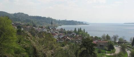 A coastal town with a prominent church, lush greenery, and a winding road.