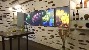 A room with a stone wall, a table with bottles and glasses, and a shelf with bottles and pottery. - Goldberg by Interhome (Pommern)