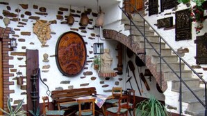 A rustic stone wall with a wooden table and chairs, a large wooden shield, and a staircase. - Goldberg by Interhome (Pommern)