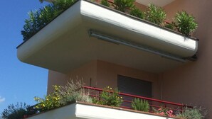 Un balcon à plusieurs niveaux agrémenté de plantes et de fleurs.