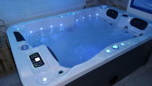 Una vasca idromassaggio con pannello di controllo e luci a LED.