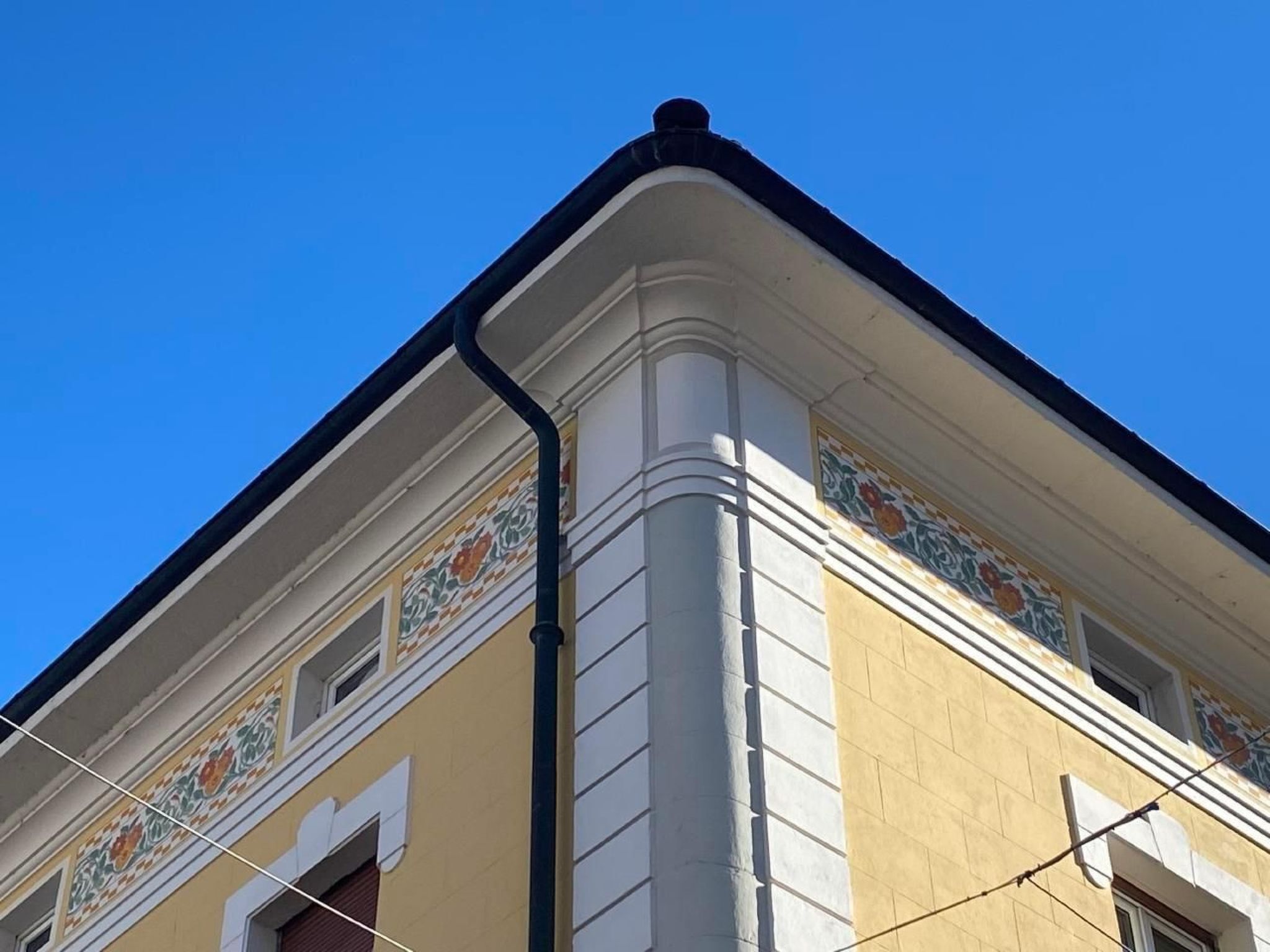 En bygning med en gul facade og dekorative fliser.